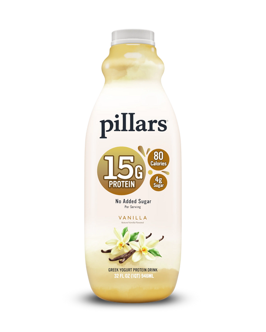 A bottle of Pillars Vanilla Green Yogurt Protein Drink, 32 fl oz, 15g protein per serving, featuring a cream-colored label with gold and brown accents, vanilla flower illustrations, and a white cap on a white background.